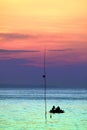 colorful of sunrise on silhouette cloud sky men on fishing boat and island