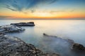 Enjoying the colorful sunset on a beach with rocks on the Adriatic Sea coast Istria Croatia Royalty Free Stock Photo