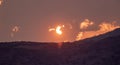 Colorful sunset in the clouds beyond the hills