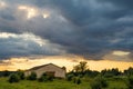 Colorful sunset with clouds in summer over a rustic farm. Royalty Free Stock Photo