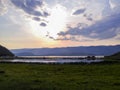 Pink, numerous cumulus clouds were lit up by the sunset in the sky. The lights of the sun. Lake Baikal. Reflections in the water. Royalty Free Stock Photo
