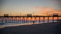 Colorful Sunset at ocean coast with silhouette of pier and photo Royalty Free Stock Photo