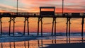 Colorful Sunset at ocean coast with silhouette of pier and photo Royalty Free Stock Photo