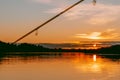 Colorful sunset over the Lielupe river in Latvia with a fishing rod in the foreground Royalty Free Stock Photo