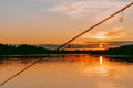 Colorful sunset over the Lielupe river in Latvia with a fishing rod in the foreground Royalty Free Stock Photo