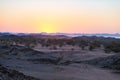 Colorful sunset over the Namib desert, Namibia, Africa. Mountains, dunes and Acacia trees silhouette in backlight. Orange red clea Royalty Free Stock Photo