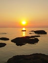 Colorful sunset over the North sea with rocks in the water