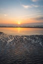 Sun sets over the sea, wave pattern in the sand Royalty Free Stock Photo