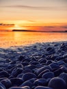 Colorful sunset over ocean, rough stone coast in foreground. Warm and cool color. Salthill beach, Galway city, Ireland. Selective