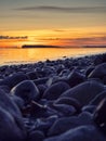 Colorful sunset over ocean, rough stone coast in foreground. Warm and cool color. Salthill beach, Galway city, Ireland. Selective Royalty Free Stock Photo