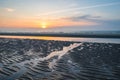 Beautiful pattern of waves and ripples in the wet sand of the beach during low tide Royalty Free Stock Photo