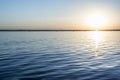 Colorful sunset over water surface, evening sun over the bay, summer sky without clouds Royalty Free Stock Photo