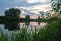 colorful sunset, river with colorful sky reflection, reeds in the foreground