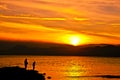 Colorful sunset on the sea with fishermen silhouettes