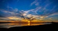 Colorful sunset sky with clouds over lake and reflection on water Royalty Free Stock Photo