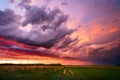 Colorful sunset sky over a dirt road and field