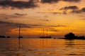 Colorful sunset on a tropical beach. Orange sunset on the ocean. Colorful sunset in the tropics. In the water is a sailing ship. Royalty Free Stock Photo