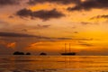 Colorful sunset on a tropical beach. Orange sunset on the ocean. Colorful sunset in the tropics. In the water is a sailing ship. Royalty Free Stock Photo