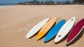 Colorful surfboards lie on the sandy beach.