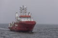 Colorful survey vessel Fugro Searcher against gray water and gray sky
