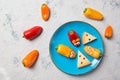 Colourful sweet mini peppers in the shape of mouses and pieces of cheese on a plate, stone table, top view, snack for kids idea Royalty Free Stock Photo