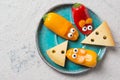 Colourful sweet mini peppers in the shape of mouses and pieces of cheese on a plate, stone table, top view, snack for kids idea