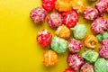 Colorful sweet popcorn on yellow background. Delicious treat for children.