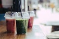 Colorful Sweet smoothie in plastic cups on wooden table