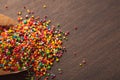 Colorful sweet sprinkles on wooden background