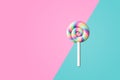 Sweet swirl lollipop on half pink and blue color background.