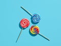 Colorful swirl round candy lollipops on blue background