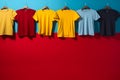 colorful t-shirts hanging on hangers against a blue and red wall Royalty Free Stock Photo