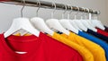 Colorful t-shirts hanging neatly on rack, minimalist fashion display Royalty Free Stock Photo