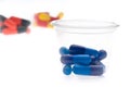 Colorful tablets, capsules in a cup