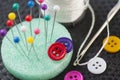 Colorful tailor\'s pins and buttons on worktable close up