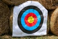 Colorful target template for sport shooting competition. Used target with color circles on shooting range against hay bales Royalty Free Stock Photo