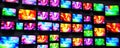 Colorful tech screens display dynamic visual content. Multiple monitors showcase various vibrant digital broadcasts. Modern