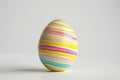 A colorful tempera-painted Easter egg stands out with its bright stripes, symbolizing the joy