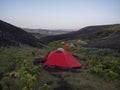 Colorful tents in Botnar campsite at Iceland on Laugavegur hiking trail, green valley in volcanic landscape among lava