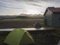 Colorful tents and green tourist hut at Alftavatn camping site with snow covered mountains and green hills and glacier Royalty Free Stock Photo