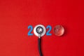 Colorful on text 2020 banner for health care and gobal medical concept. black stethoscope,on table red background