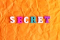 Colorful text SECRET on crumpled paper background