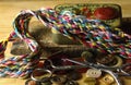 COLORFUL THREAD BRAID ON OLD METAL PIN BOX WITH BUTTONS AND SEWING AIDS IN THE BACKGROUND Royalty Free Stock Photo