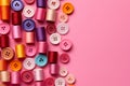 Colorful thread spools and buttons on pink background, top view Royalty Free Stock Photo