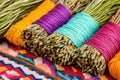 Close-up view of sage and cedar bundles wrapped in colorful threads on a vibrant Native American patterned cloth Royalty Free Stock Photo