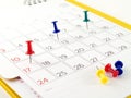 colorful thumbtacks tack on date in opened desk calendar page Royalty Free Stock Photo