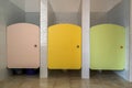 Colorful toilet doors in elementary school bathroom interior