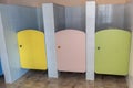 Colorful toilet doors in elementary school bathroom interior
