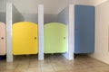 Colorful toilet doors in elementary school bathroom interior