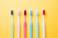 colorful toothbrushes against a yellow background